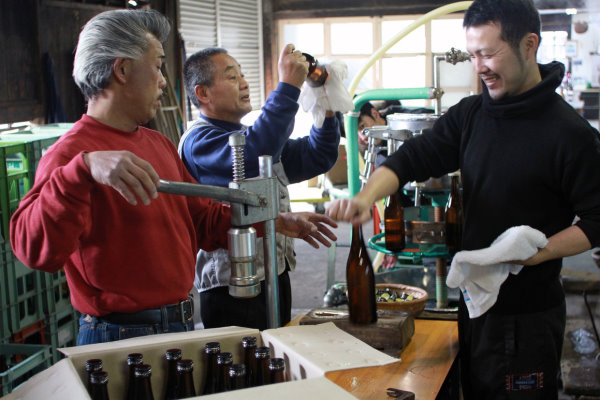 des personnes avec une bouteille de saké et des machines