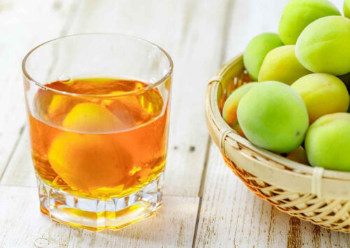 Verre avec de l'umeshu et des prunes